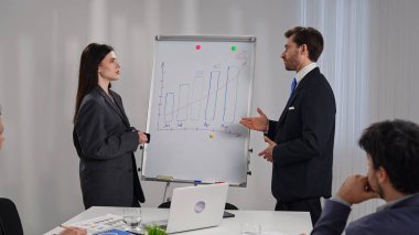 İş dünyasından profesyonellerden oluşan bir ekip, bir çalışma ortamında verileri analiz etmek ve stratejileri tartışmak üzere bir tablonun etrafında toplandı..