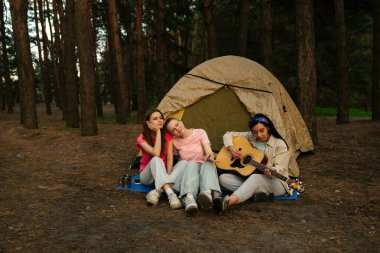 Üç arkadaş ormanda bir çadırda oturur, müziğin ve doğal çevrenin tadını çıkarır, anılar yaratırlar..