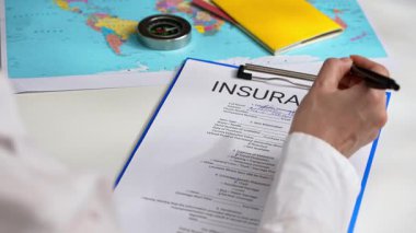 Ofiste seyahat sigortası formunu belgelemek, ajanların ellerini kapatmak. Bir kişi, anlaşmaların güvence altına alınmasında dikkatli belgelerin önemini vurgulayan önemli sigorta belgelerini imzalar.