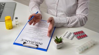 Sigorta acentesi müşteriye ofisteki yaşam ve sağlık sigortasının koşullarını ve şartlarını söyler..