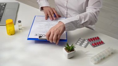 Sigorta acentesi ve müvekkil hastane ofisinde sağlık sigortası belgesini imzalarlar..