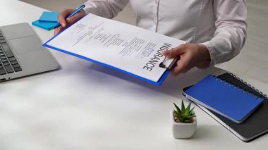 Sigorta acentesi ve müvekkil ofiste sigorta belgesini imzalar ve anlaşma işareti olarak el sıkışırlar. Sigorta belgesinin ofiste kaydı var..