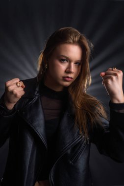 Bir kadın, kararlı bir ifade ve güçlü bir pozla duran deri cekete güç ve güven gösterir. Moda yazıları, giyim markaları veya aksesuar reklamları için..