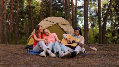 Üç arkadaş ormanda bir çadırda oturur, müziğin ve doğal çevrenin tadını çıkarır, anılar yaratırlar..