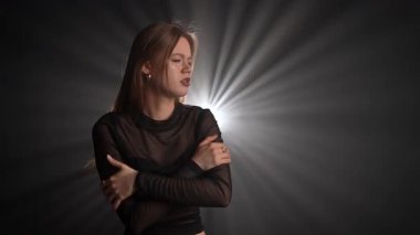 Siyah deri ceketli bir kadın koyu bir arka plana karşı özgüvenle poz verir, zarafet ve tarz yayar. Moda yazıları, giyim markaları veya aksesuar reklamları için..