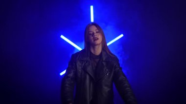 Siyah deri ceketli bir kadın koyu bir arka plana karşı özgüvenle poz verir, zarafet ve tarz yayar. Moda yazıları, giyim markaları veya aksesuar reklamları için..