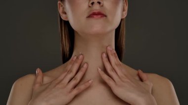 Bir kadın boynuna nemlendirici krem sürüyor, cilt bakımına ve daha iyi cilt sağlığı için hidrasyon tekniklerine odaklanıyor..