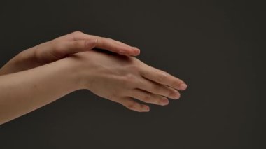 Bir insan eline nazikçe losyon sürer, cilt bakımını ve hidratlaşmayı vurgular..