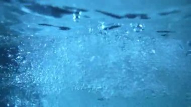 dinamik bir sualtı sahnesi kabarcıkların hareketlerini gösteriyor berrak, mavi bir suda.