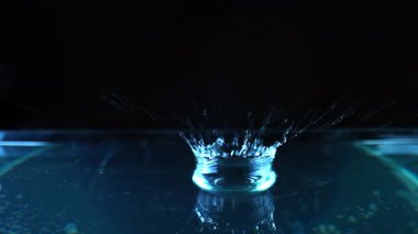 Su damlacıklarının karmaşık detaylarını vurgulayarak canlı mavi ışıkta çekilen büyüleyici bir görüntü..