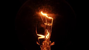 Siyah arka plan üzerinde Tungsten ampul lamba. Aydınlık ve karanlık kavramı, fikir, modern evde elektrik