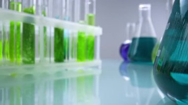 İçinde yeşil sıvı ve su bitkisi örnekleri bulunan üç test tüpü bir laboratuvar ortamında düzenlenir. Görüntü, bilimsel analiz, biyoteknoloji ve botanik deneylerini vurguluyor..