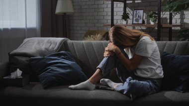 Kanepede oturan bir kadın üzüntüsünü dile getiriyor. Düşüncelere daldıkça başı dizlerinin üzerinde duruyor..