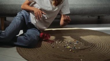 Genç bir kadın kanepenin önünde çeşitli haplarla yatıyor. Depresyona odaklan. Yavaş çekim