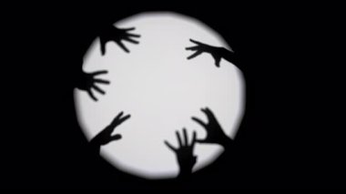 Siluetli eller dairesel bir ışığa karşı sanatsal şekiller oluşturarak ilgi çekici bir gölge oyunu yaratır. Yavaş çekim