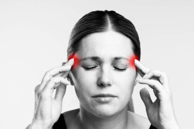 Şakaklarını, şiddetli bir baş ağrısı ya da migrene işaret eden vurgulanmış ağrı bölgeleriyle tutan bir kadın görülüyor. Sağlık, tedavi ve ağrı kesici kavramı.