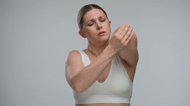 Bir kadın acı veren dirseğine dokunuyor, kırmızı bir ışıkla belirtilmiş, acı ya da rahatsızlık hissi veriyor. Sağlık, tedavi ve ağrı kesici kavramı.