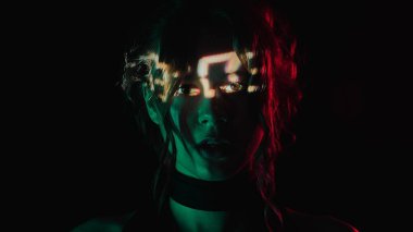 Yüzünde dijital saat projeksiyonu olan bir kadının portresi. Yaşamın geçiciliği kavramı.