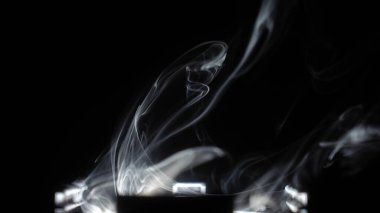 Siyah arkaplanda kopyalama alanı olan soyut duman arkaplanı. Beyaz duman yükseliyor.