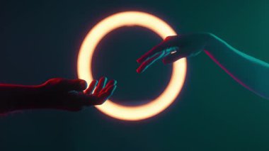 İki el birbirine doğru uzanır, arka planda parlayan bir yüzükle aydınlanır, bağlantı ve iletişimi simgeler..