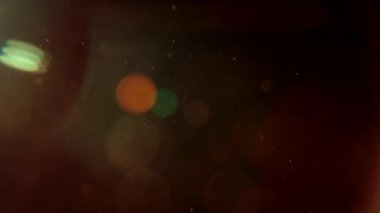 Soyut altın parçacıkları havada süzülür. Siyah bir zemin üzerinde izole edilmiş sıcak sarı bir ışıltıyla rüya gibi ve sinematik bir atmosfer yaratır..