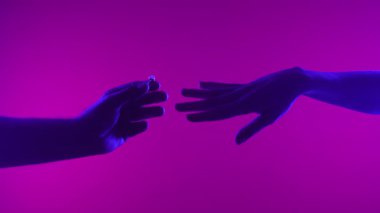 Bir el, sanatsal bir ortamda romantik bir teklifi sembolize eden neon ışıklı bir yüzük sunar..