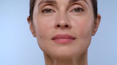 Bir kadın, çenesine eldiven takmış profesyonel bir el tarafından estetik iğne vurulur. Bu da tıbbi estetik prosedürü yakından temsil eder.