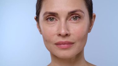 Bir kadın, çenesine eldiven takmış profesyonel bir el tarafından estetik iğne vurulur. Bu da tıbbi estetik prosedürü yakından temsil eder.