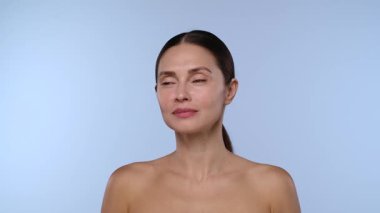 Bir kadın gözüne yakın bir yerde, eldiven giyen bir profesyonel tarafından yapılan kozmetik enjeksiyonunu alır..