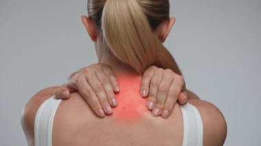 Boyun bölgesi belirgin bir şekilde ağrıyan bir kadın. O bölgede rahatsızlık ya da yaralanma olduğunu gösteriyor. Sağlık, tedavi ve ağrı kesici kavramı. Arka plan.