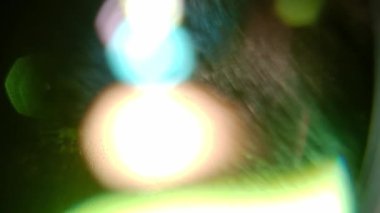 Siyah arka planda gerçek optik mercek parlaması. Işık geçişi, prizma etkisi, ışık sızıntısı.