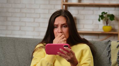 Kadın evde boş vakit geçiriyor. Genç bir kadın bütün gününü evinde, oturma odasındaki kanepede oturarak, elinde akıllı bir telefonla sosyal medyayı karıştırarak, film izleyerek, şok olmuş bir ifadeyle geçirir..