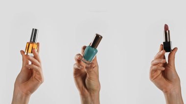 Parfüm, oje ve ruj gibi güzellik ürünlerini arka planda tutan bir set..