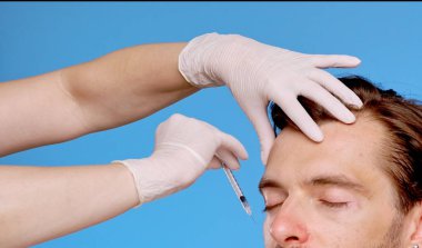 Yüz hatlarını geliştirmek, cilt bakımını ve estetik gelişim tekniklerini göstermek için deri enjeksiyonu alan bir adam..