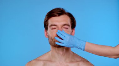 Bir adam estetik ameliyata hazırdır. Yüzünde işaretler vardır. Erkekler için estetik ameliyatlar, estetik cerrahi ve cilt bakımı ile ilgili içerik için ideal.