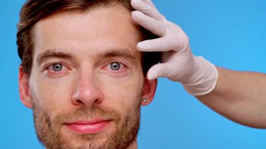 Yüz hatlarını geliştirmek, cilt bakımını ve estetik gelişim tekniklerini göstermek için deri enjeksiyonu alan bir adam..