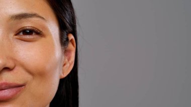 İnce bir gülümsemeyle bir kadının doğal güzelliğini ve dokusunu yansıtan yakın plan bir görüntü..