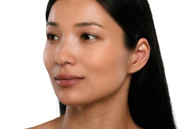 Yan tarafa bakan, doğal derisini ve uzun siyah saçlarını sergileyen genç bir kadının yakın plan portresi..