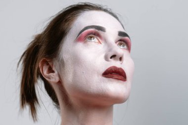 Çarpıcı bir portre dramatik makyajlı, çarpıcı renkler ve canlı bir ifade sergiliyor..