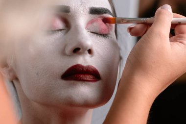 Artistik makyaj uygulamasının kapatılması fırçalar kullanarak çarpıcı bir görünüm yaratmak için kalın, canlı renkler.