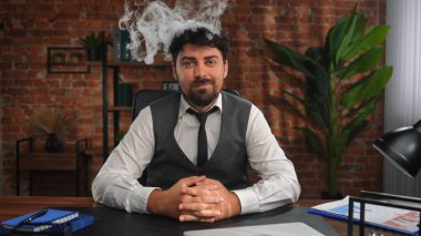 Bir iş adamı çatı katı tarzı bir ofiste çalışır ve aşırı çalışmaktan stres altındadır. İnsan kafasından duman yükselir, iş yükünden ve zor işlerden duyulan rahatsızlığı simgeler..