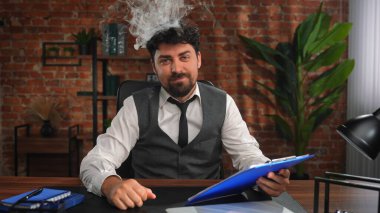 Bir iş adamı çatı katı tarzı bir ofiste çalışır ve aşırı çalışmaktan stres altındadır. İnsan kafasından duman yükselir, iş yükünden ve zor işlerden duyulan rahatsızlığı simgeler..