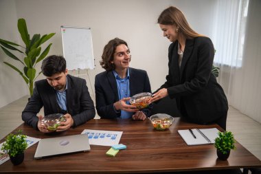 Üç meslektaş, gelişigüzel bir ofis toplantısında potansiyel büyüme çizelgelerini tartışarak sağlıklı bir öğle yemeğini paylaşıyor..