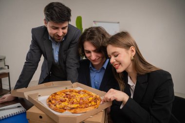 Bir ofis ortamında pizzanın tadını çıkarmak için mola veren bir iş ekibi takım ruhunu ve arkadaşlığı geliştirdi..