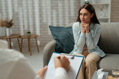 Günlük yaşam tarzı konsepti. Yaşlı yetişkin kadın zihinsel tedavi görüyor, kadın psikoterapiste gidiyor, kanepede oturuyor sorunlardan bahsediyor, depresif bir yüz ifadesi var..