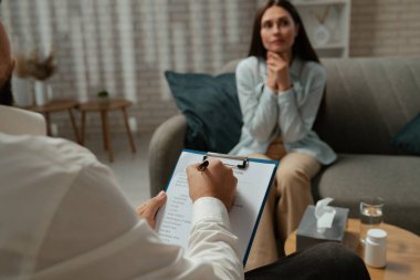 Günlük yaşam tarzı konsepti. Yaşlı yetişkin kadın zihinsel tedavi görüyor, kadın psikoterapiste gidiyor, kanepede oturuyor sorunlardan bahsediyor, depresif bir yüz ifadesi var..