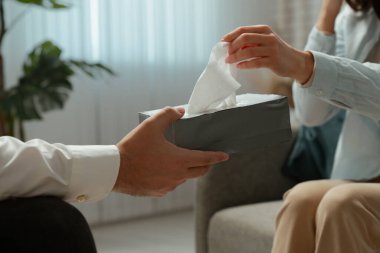 Ofisteki bir erkek, bir kadına duygusal bir anda huzur ve destek sağlamak için mendil sunar..