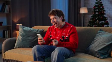 Çiftler tatillerini evde geçiriyorlar. Yeni yıl arifesini evinde kutlayan adam, akıllı telefonuyla koltukta dinlenen adam, iyi haberler almayı bekleyen, mutlu kazanan yüz ifadesi. Yavaş çekim