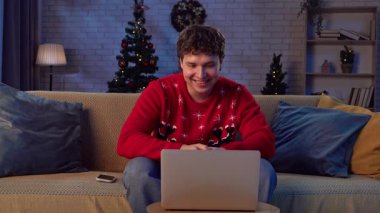 Çiftler tatillerini evde geçiriyorlar. Adam yeni yıl arifesini rahat bir evde kutluyor, kanepede oturuyor ve ailesiyle ya da arkadaşlarıyla bilgisayarla konuşuyor, olumlu ifade..