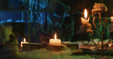 A spooky Halloween scene featuring candles, a skull, and cobwebs, creating a mysterious and eerie atmosphere.